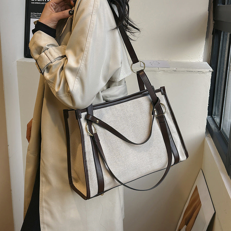 Person holding a EMILY beige canvas handbag with brown straps 