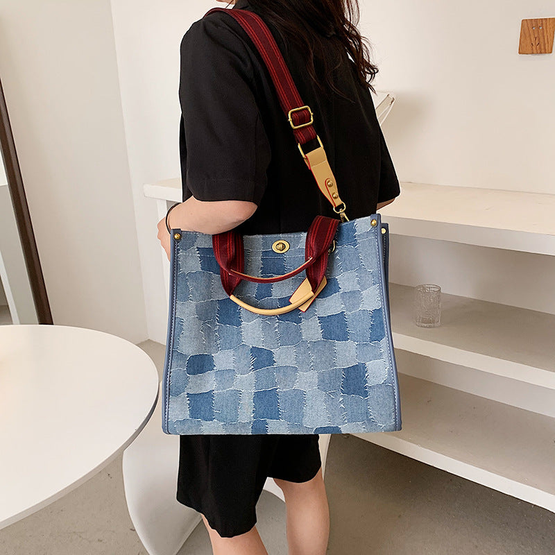 Person holding large size AMANDA blue denim style patterned handbag with red straps